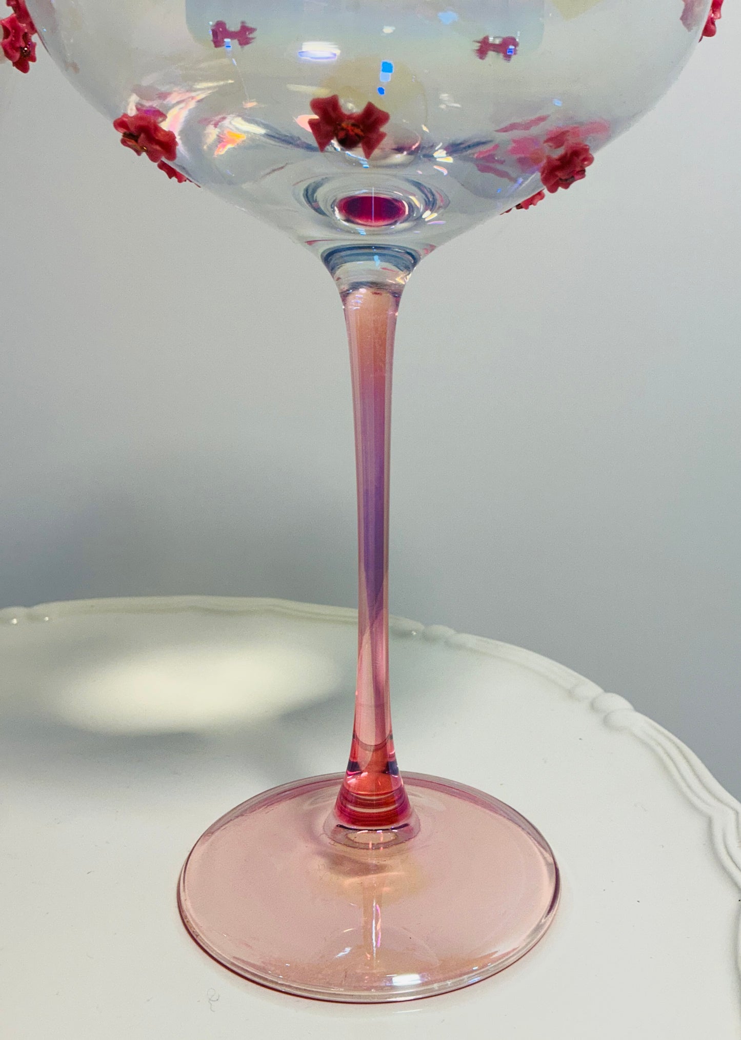 Set of 2 Iridescent pink coupe glasses feature a stem-to-base ombré effect decorated w/red bows 7”