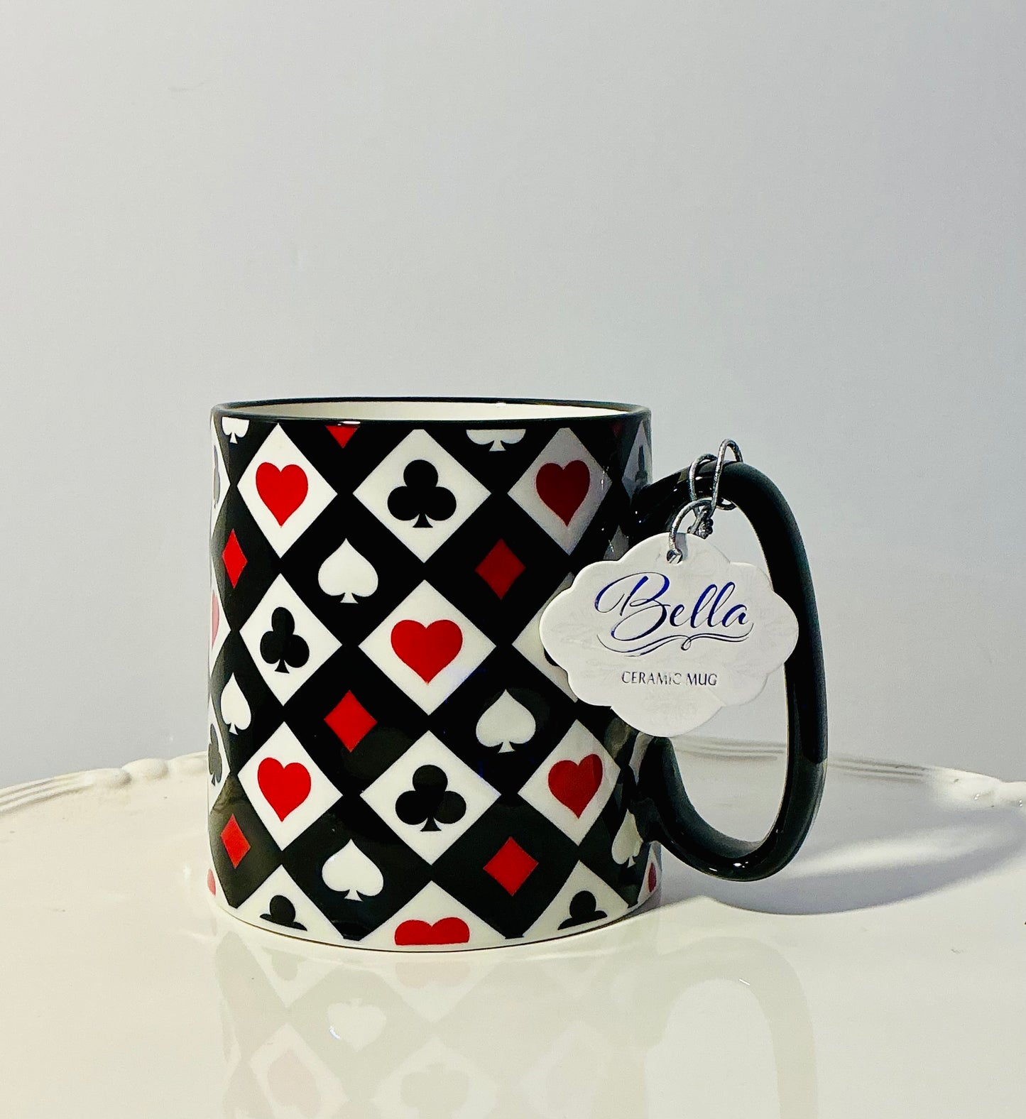 Bella Ceramics Mug features a black,red & white playing card suit pattern 4”x3.5”