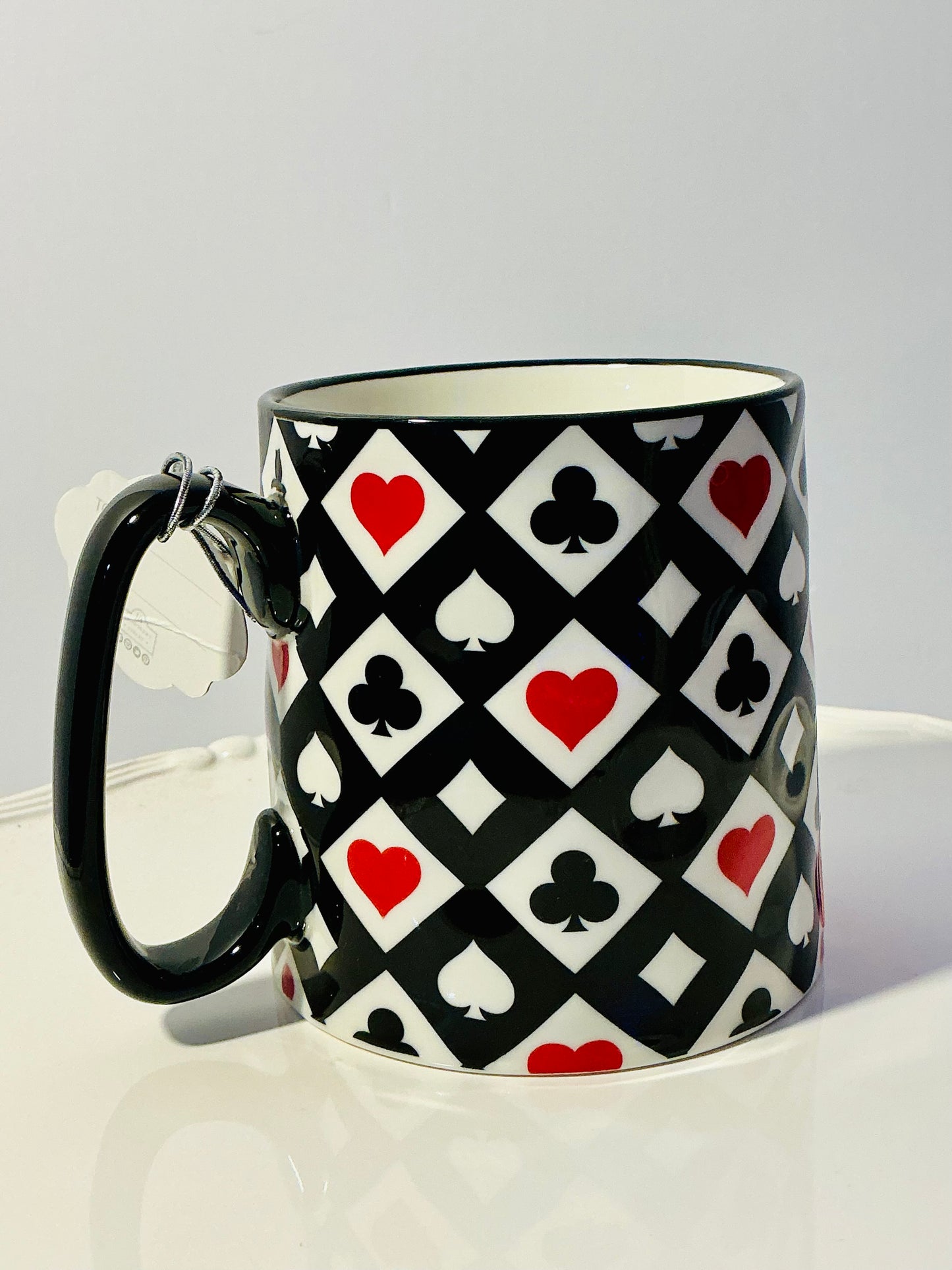 Bella Ceramics Mug features a black,red & white playing card suit pattern 4”x3.5”
